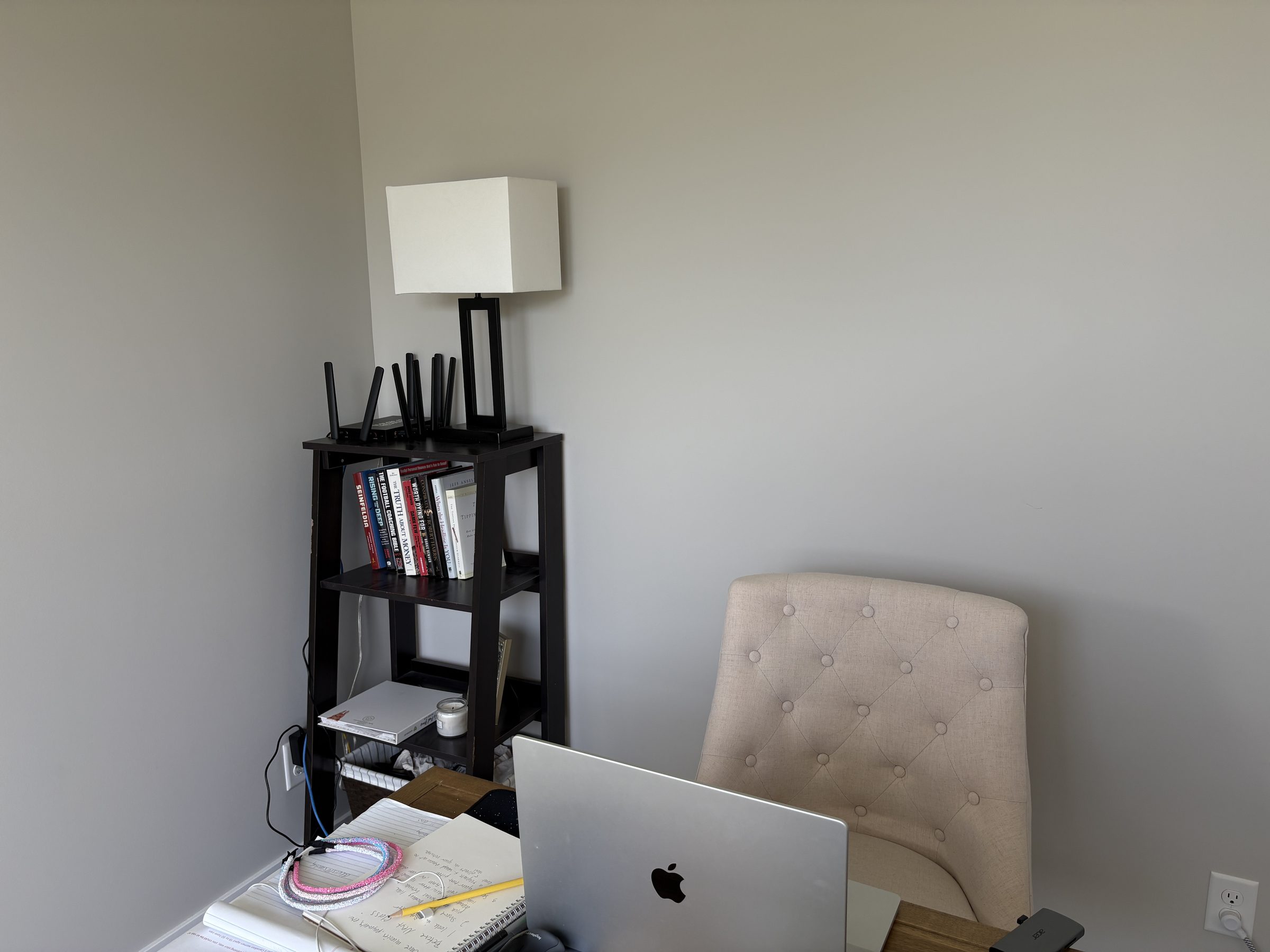 Connecten router on a bookshelf in a home office beside a lamp and laptop